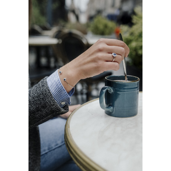 Bague Océan en argent 925 rhodié avec pierre bleue ovale et halo d’oxydes de zirconium - vue portée